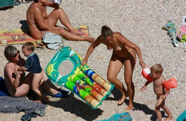 Nudists sunbathe on a beach